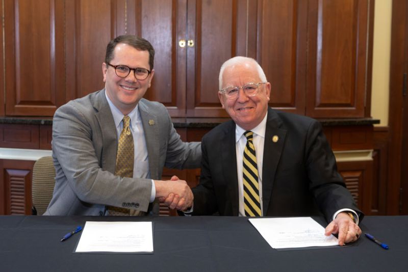 MC President Blake Thompson, left, and USM President Joe Paul congratulate one another after signing the 3+3 partnership.