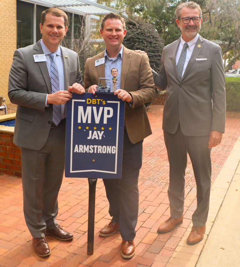 Mississippi College President Blake Thompson, left, presents his DBT's MVP Award for November to Jay Armstrong, center, while MC Law Dean John Anderson observes.